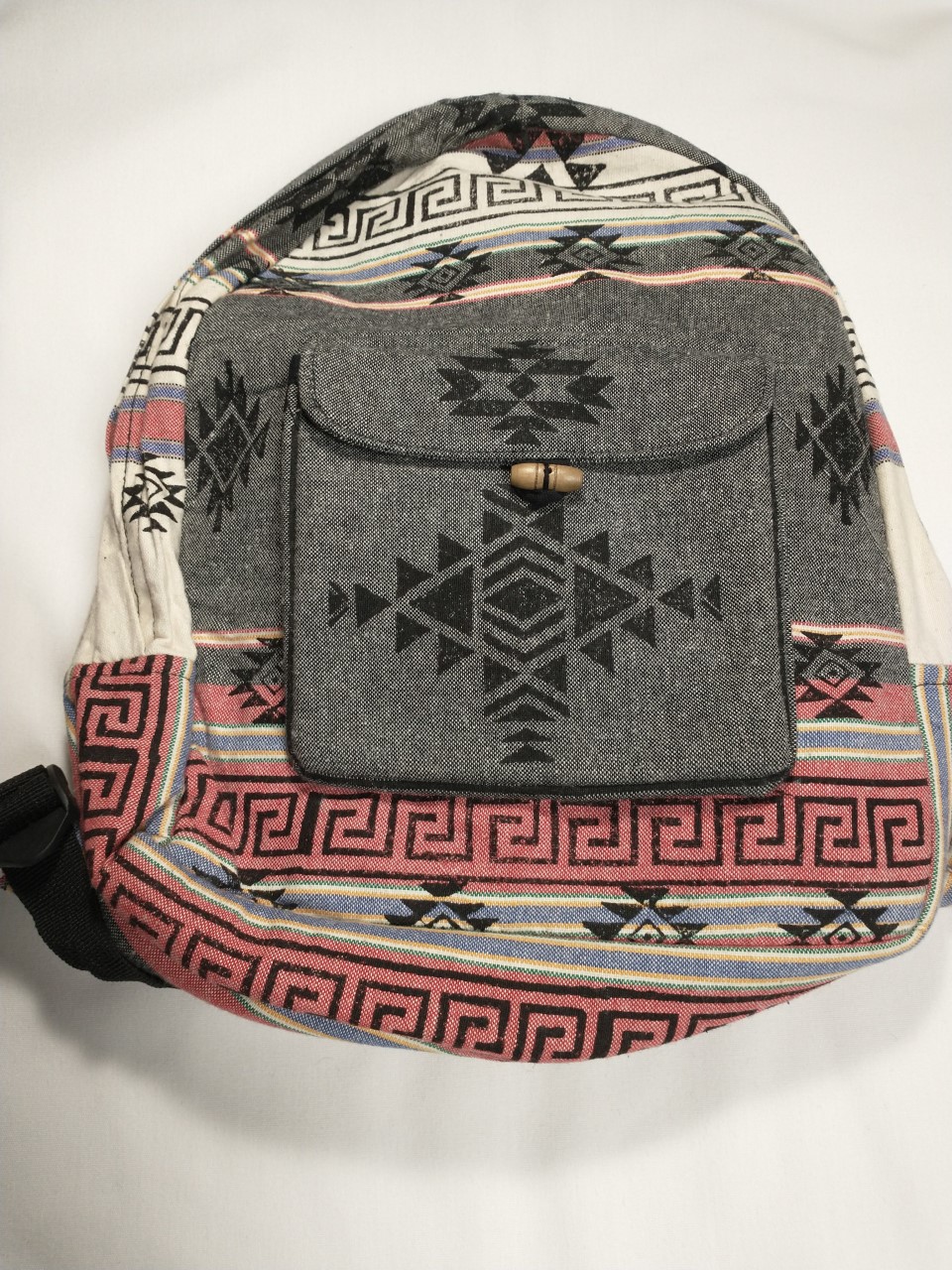 Gray, pink, and white backpack with triangle and block patterns